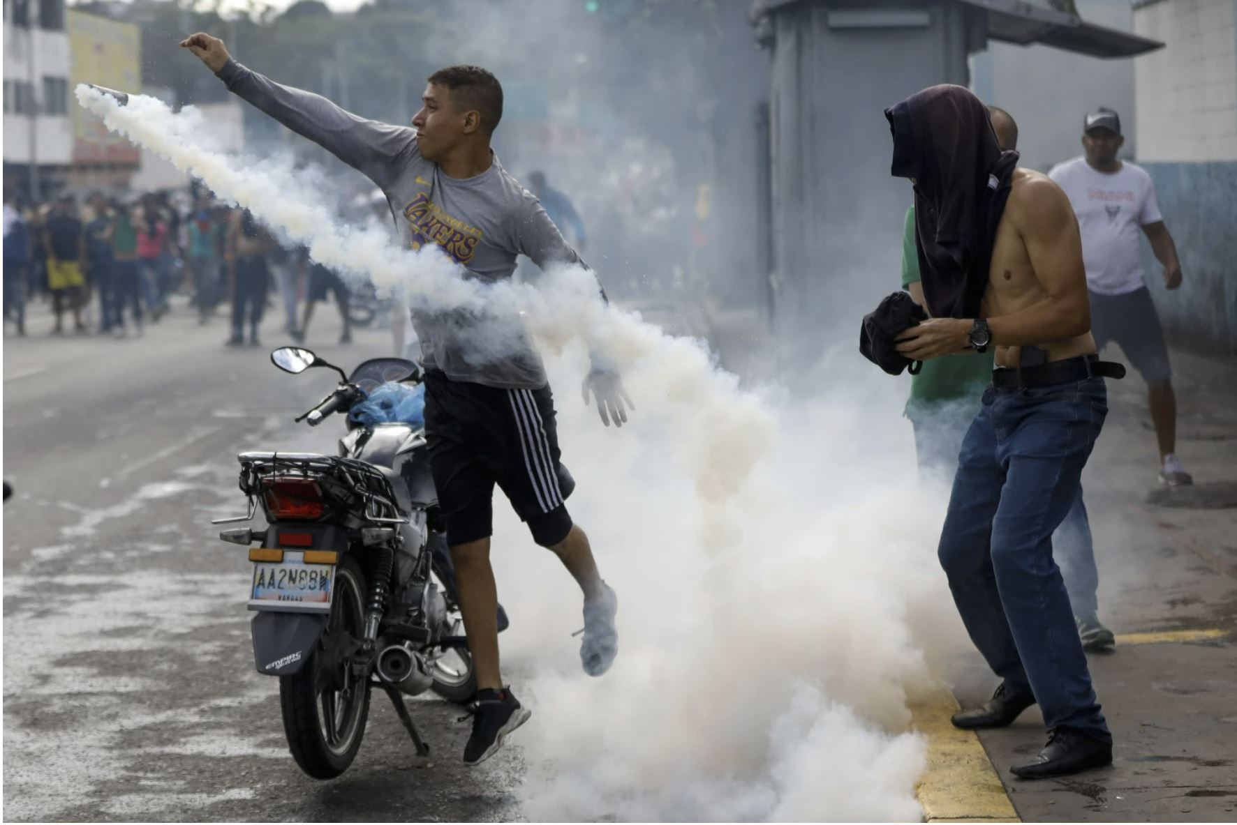 Протестующий бросает газовый баллончик в полицейского