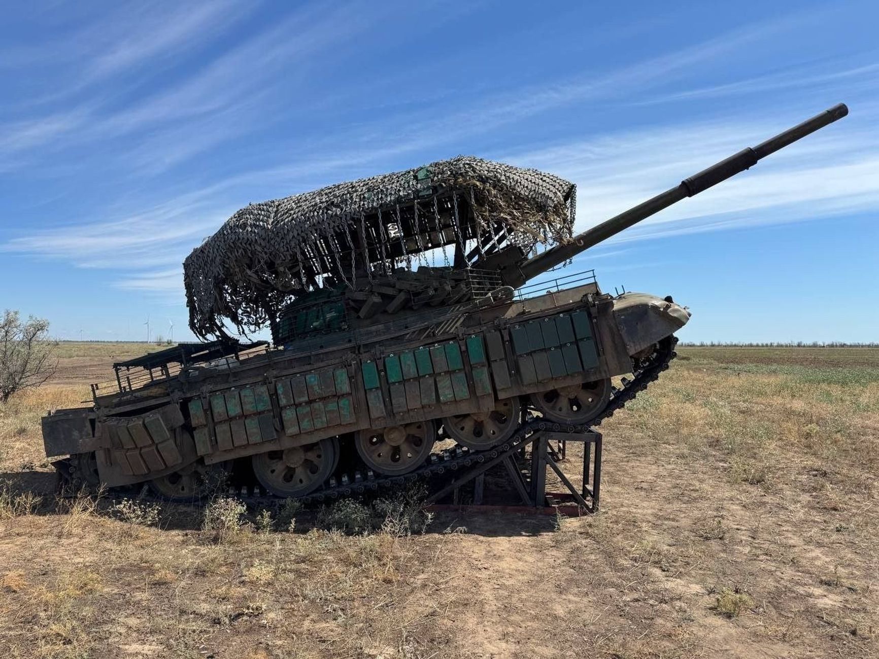 Российский танк Т-62М с динамической защитой, «мангалом» и специальной металлической рампой для увеличения угла возвышения орудия
