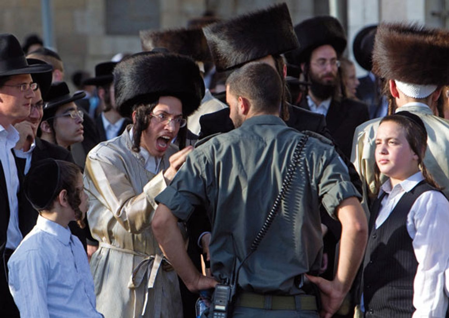 An ultra-Orthodox Jew arguing with a soldier